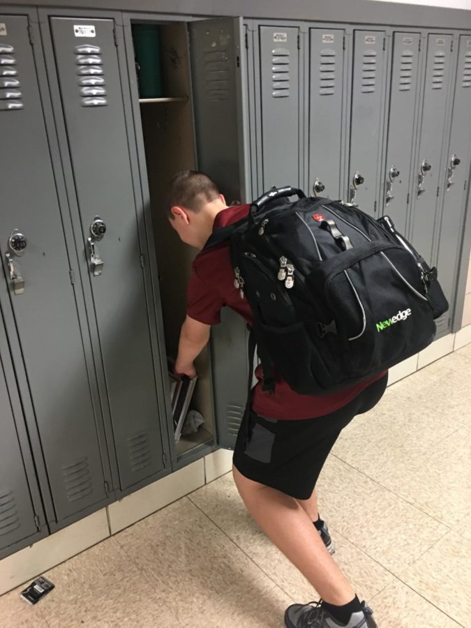 Freshman Jonah Sprandel trying to find room for all of his books in his locker. 