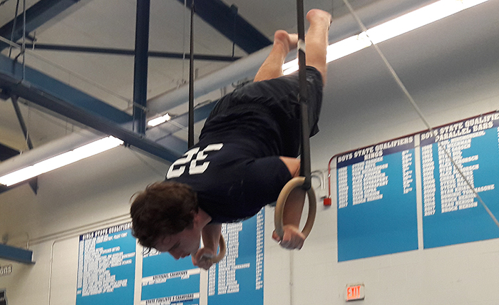 Freshman Jimmy Riedel practicing his routine on the rings during team practice..