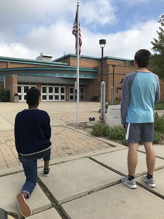 Paul Szmanda and Rhaya Truman gaze at the American flag by the West Events Entrance.