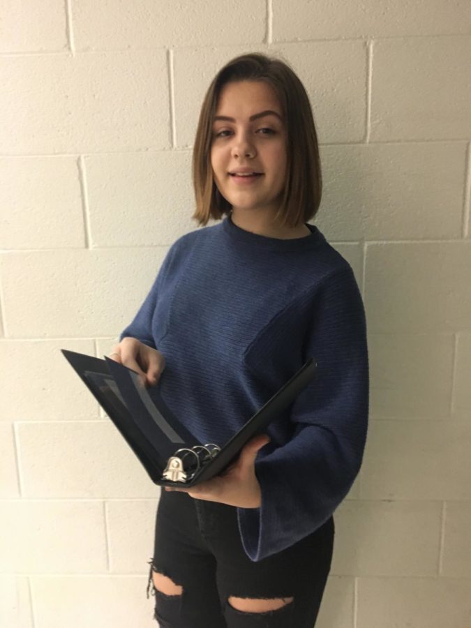 Freshman Gwen Royle poses with her prose book, practicing for an upcoming speech competition.