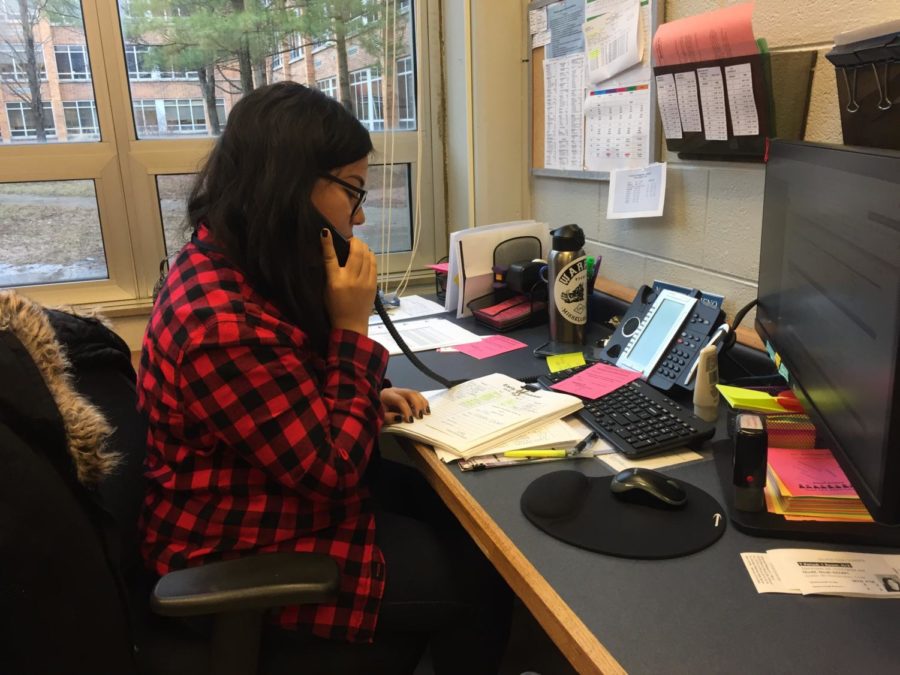 Attendance secretary Naybeth Moreno operating the phone in the attendance office.