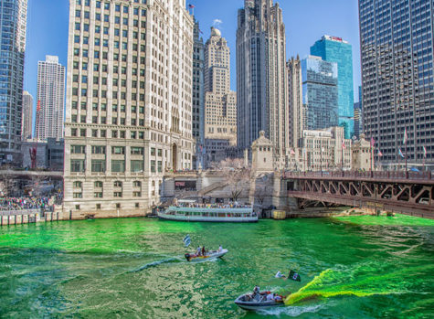 Two boats pouring dye into the Chicago river to make the river neon green for St. Patricks Day. 