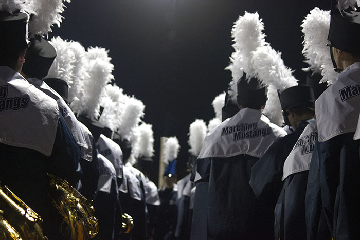 The Marching Mustangs marching band preparing to take the field during the pregame show. Since the temperature was 40 degrees, the marching band wore long coats that displayed their Marching Mustangs logo on the back. 