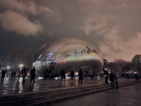 Cloud Gate, located in Millennium Park reflects the Chicago skyline and overlooks the McCormick Tribune ice rink.