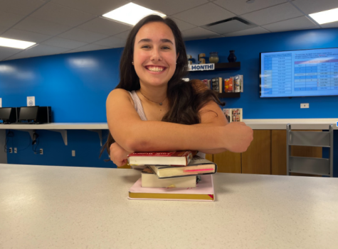 Sophomore Juliana Conyer poses with her three favorite books and her journal she uses to brainstorm creative writing ideas.