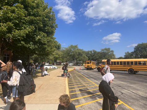 Students wait for their bus as they are looking at earlier buses leaving. 