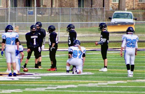 Gracie Swierczynski (97) khelt down surrounded by her teammates and opponents before beginning the next play. 