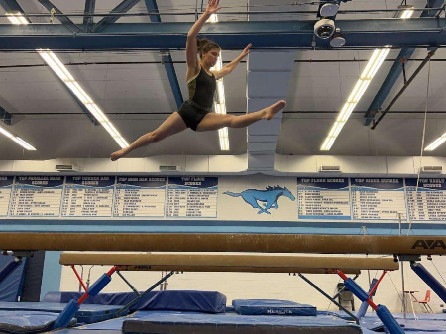 Piotrowski+performs+a+leap+on+the+high+beam+in+preperation+for+her+first+meet+of+the+season.
