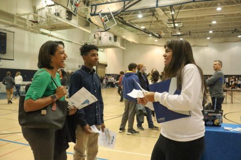 Junior Nahla Mokkath promotes DECA to an incoming freshman. DGS held Future Mustang Night on Jan. 23 to give the incoming freshman a look into student life. Mokkath was one of many students who helped to promote the activities that they participate in. 