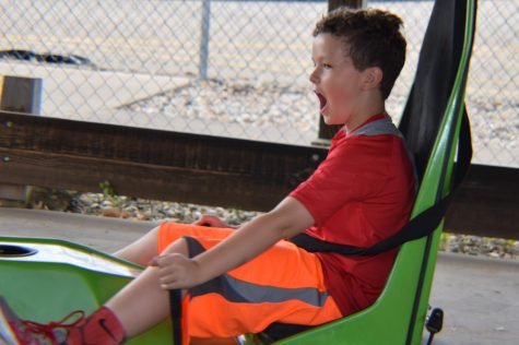 A young Luke Willer takes on bumper carts, clad in neon.