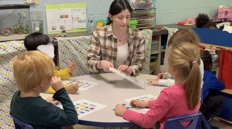 Senior Tia Ramahi teaches a group of her students an educational game to play. 