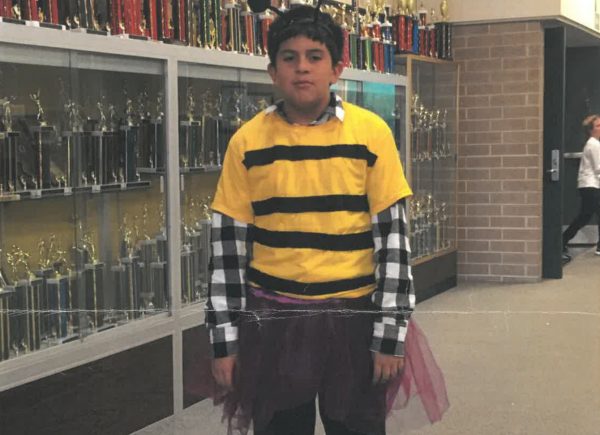 I stand with zero shame in the middle of my junior high school common area dressed as a bee in a tutu, my costume for our performance.