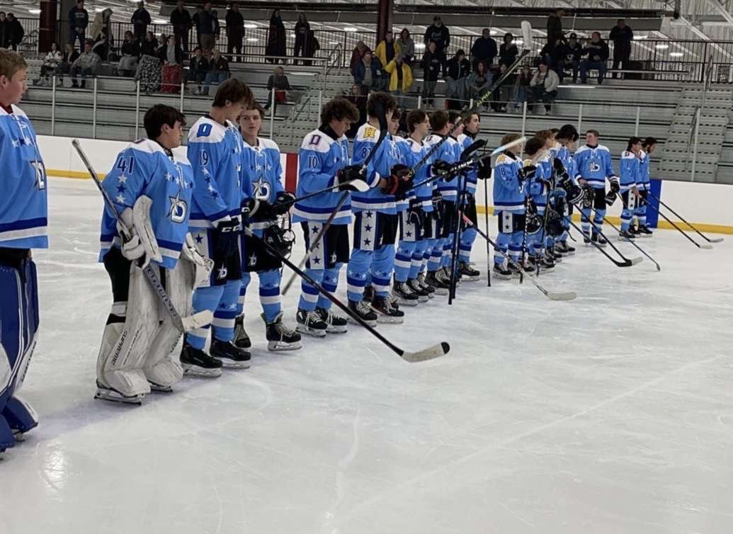 +The+varsity+hockey+team+lines+up+for+the+national+anthem+before+playing+the+Plainfield+Predators.+