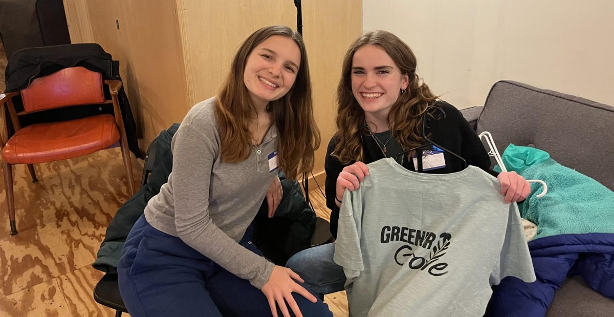Juniors Noelle Kelly (left) and Becca Snouffer (right) pose with a newly made Greener Grove shirt at their end-of-the-year party. 