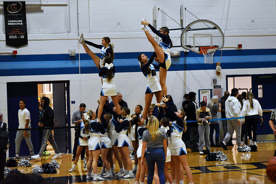 Cheerleaders stunt at basketball games every week, which serve as practice for the upcoming state competition.