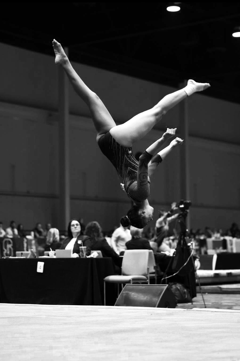 Senior gymnast Zoe Claiborne performs her floor routine during her competition.