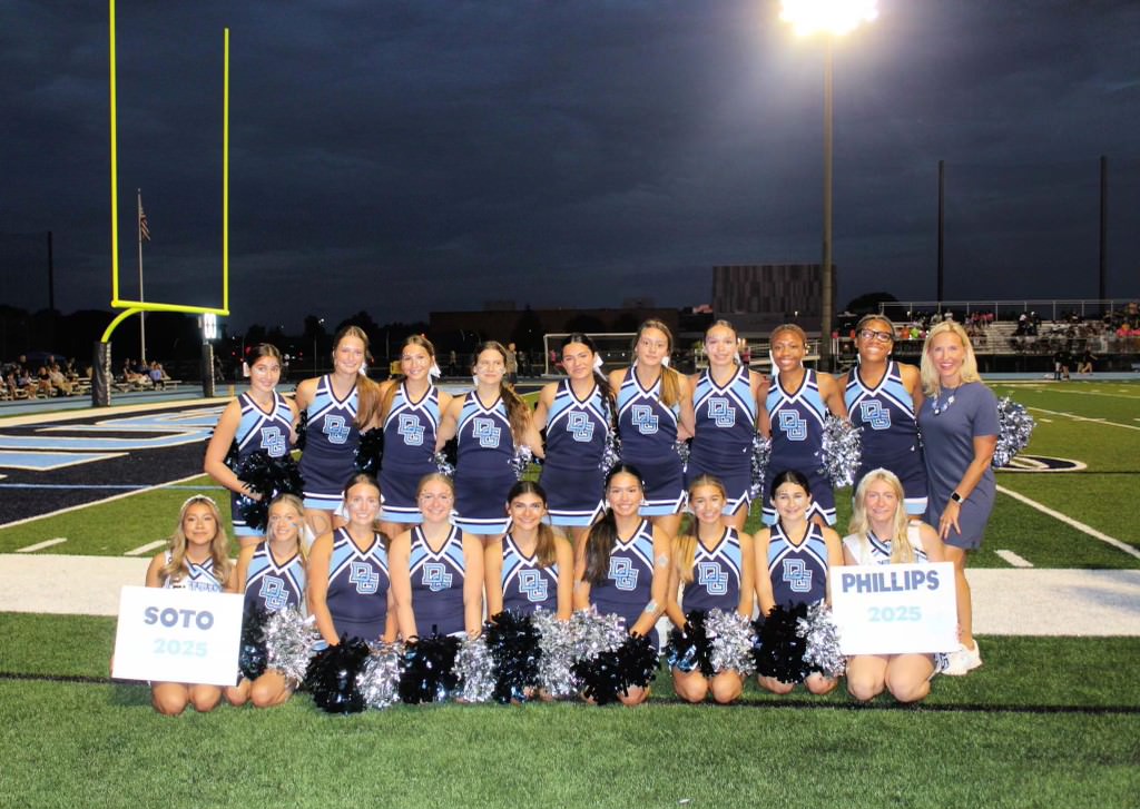 Varsity cheer squad poses for a picture during senior night.