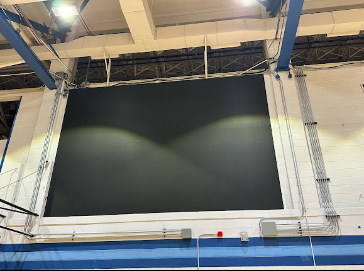 The new digital scoreboard in the large gym is located above the home side court and next to the student section. 