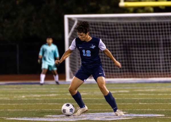 Senior varsity soccer player Sammy Smazil dribbles in preparation to pass the ball to his teammate..