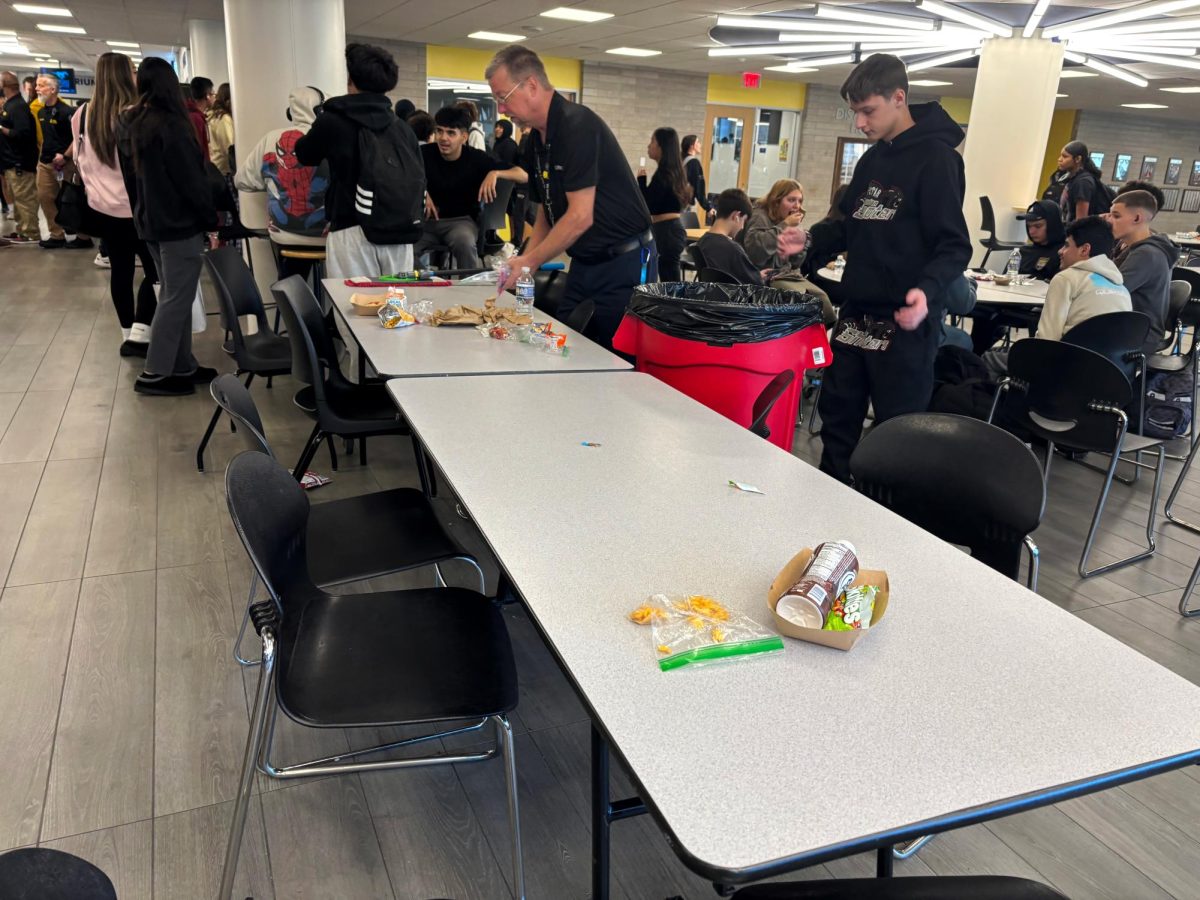 Custodian cleans up messes that students leave during their lunch periods in the commons.