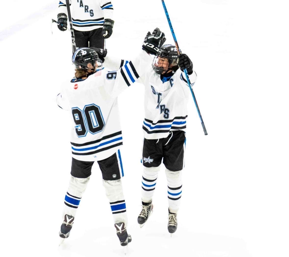 Senior hockey player Jaxon Flakus and his teammate celebrate the game winning goal.