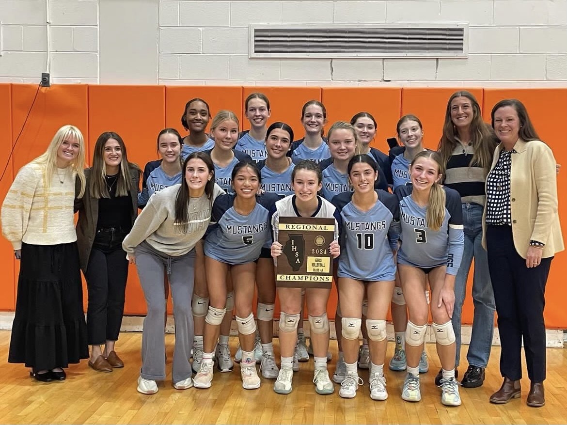 The varsity girls volleyball team poses after defeating Willowbrook in 3 sets to win the regional championship.