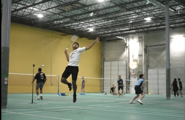 Senior Aaron Brijesh jumps high to deliver a powerful smash in practice.
