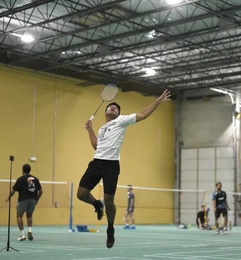 Senior Aaron Brijesh jumps high to deliver a powerful smash in practice.
