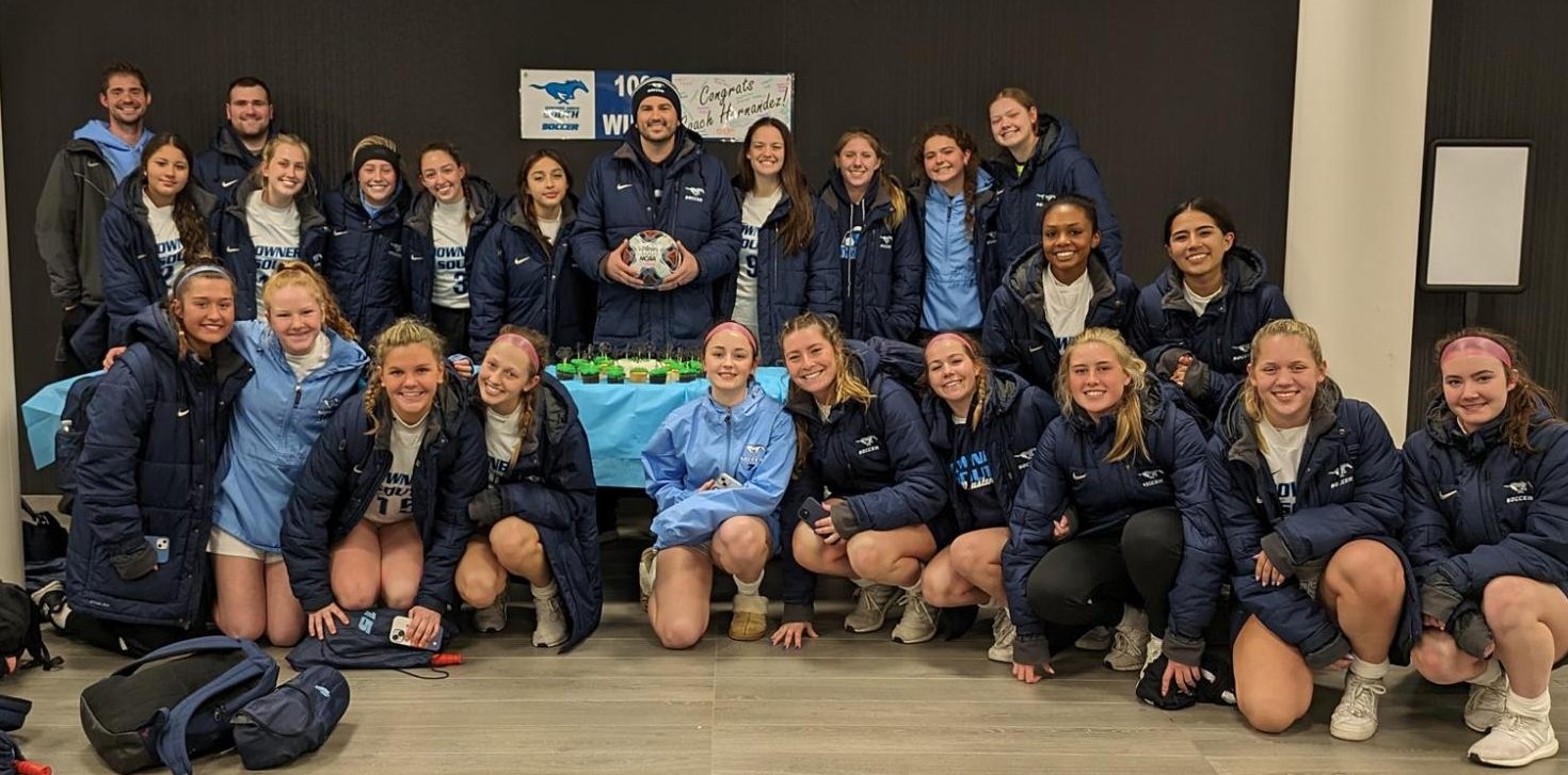 Varsity head coach for boys and girls soccer Christopher Hernandez  poses with  the girls soccer team.