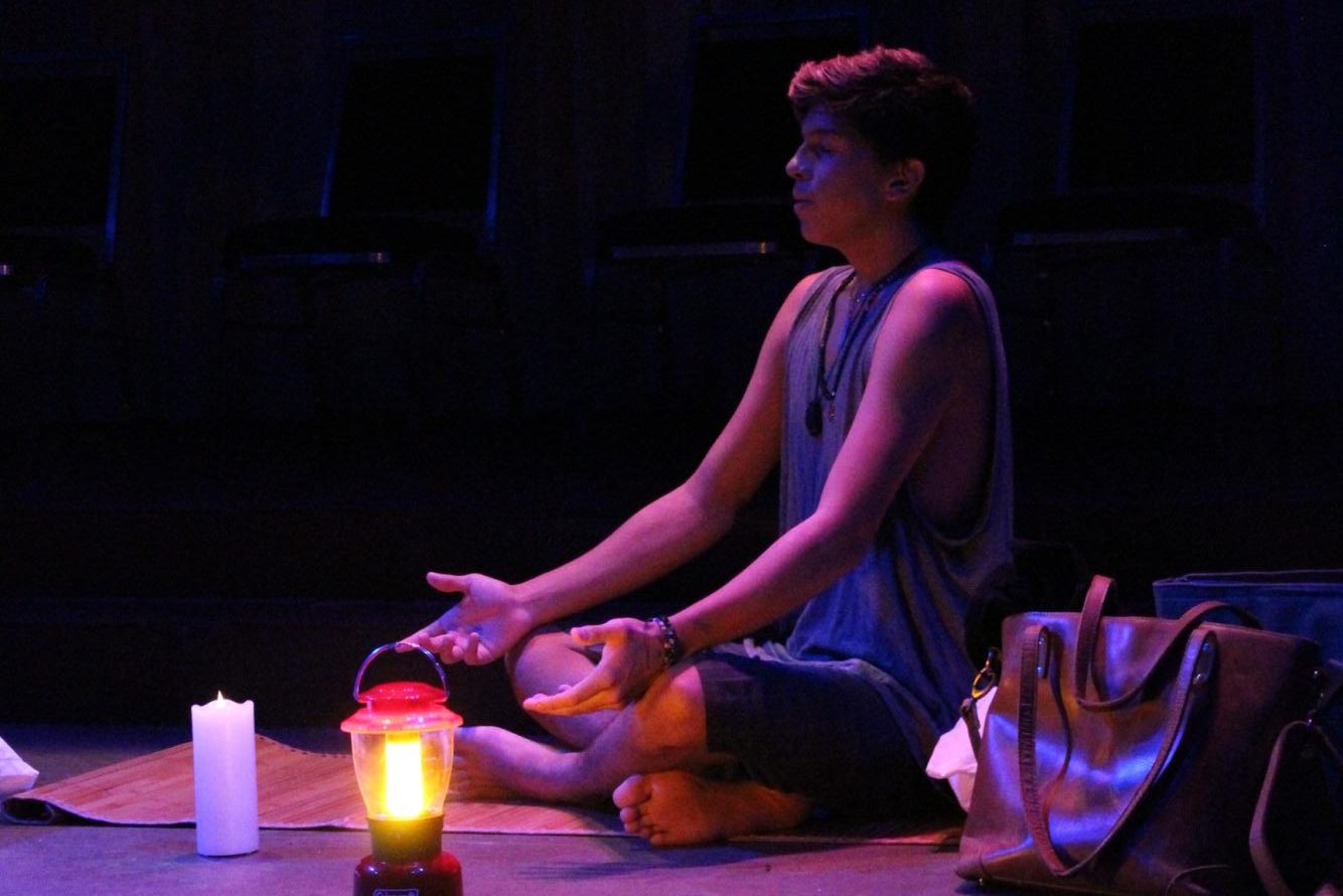 Then-sophomore Sebastian Blanco sits barefoot onstage during the final dress rehearsal of Bess Wohl's "Small Mouth Sounds."