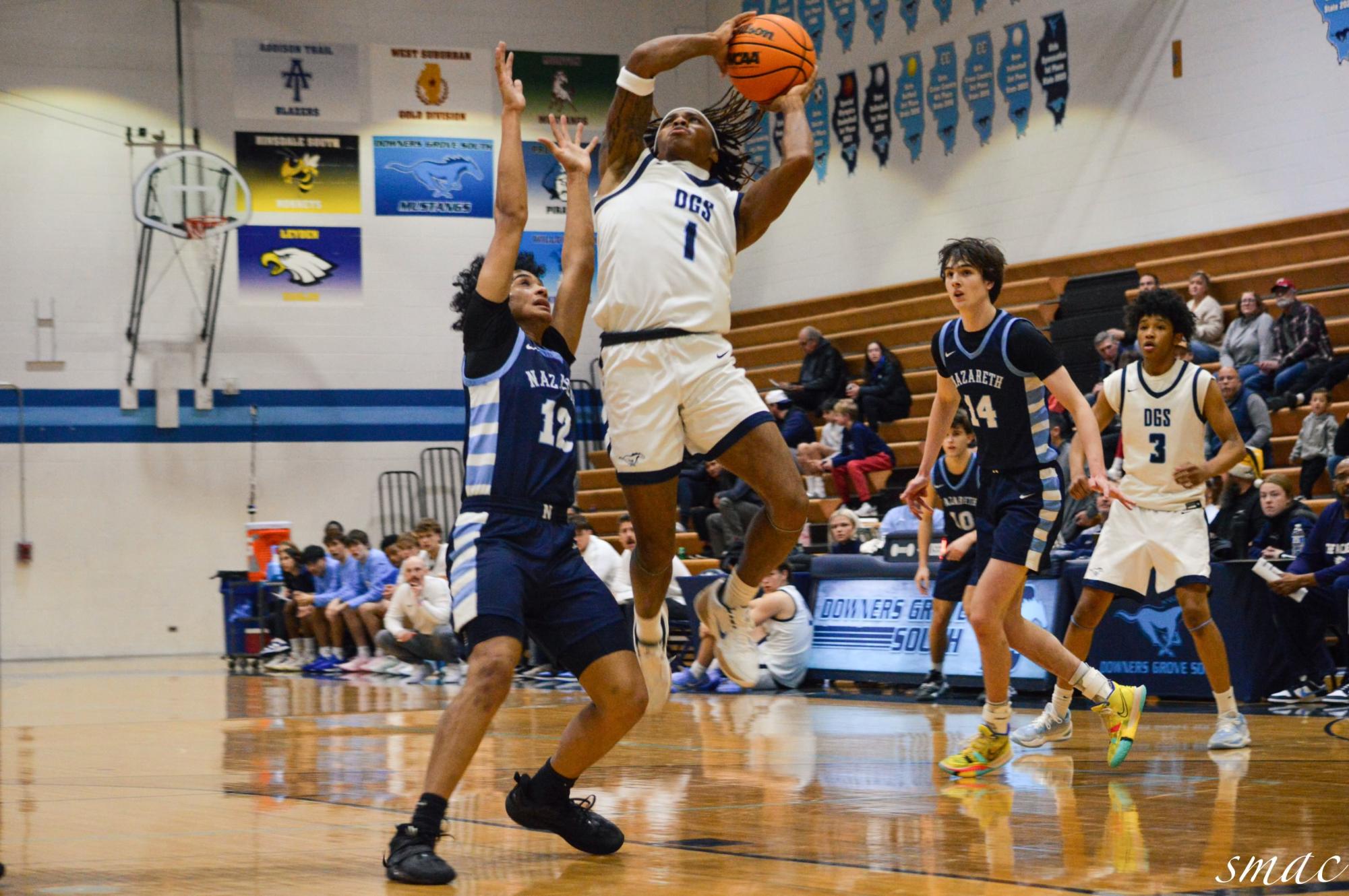 Starting guard Keon Maggit goes in for a layup against Nazareth starting point guard Rasim Johnson. 