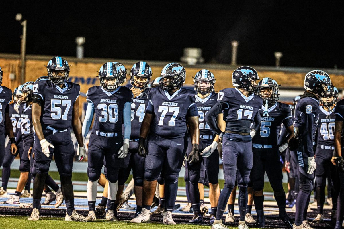 Isaiah Rieves number 57 stands with his fellow Mustang football teammates.