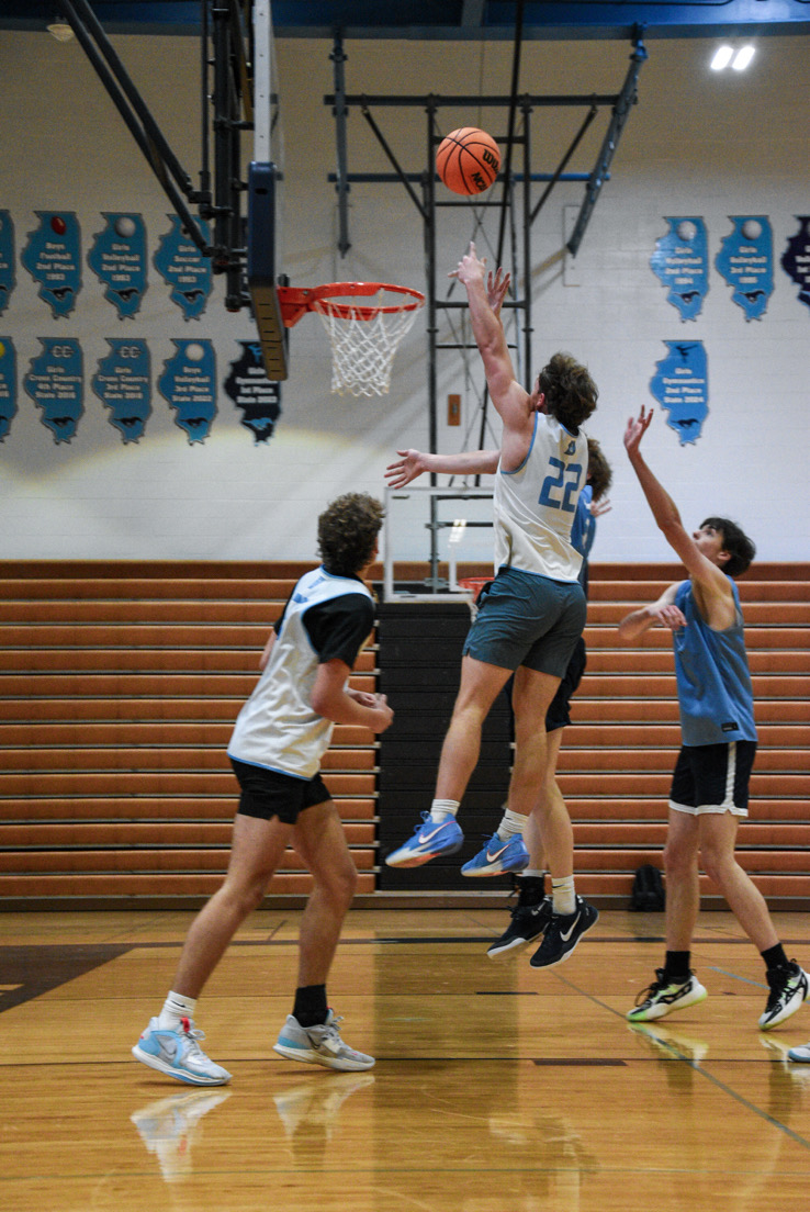 Varsity senior guard Daniel Laurich glides up the rim to score a layup during the Blue vs. White scrimmage. 