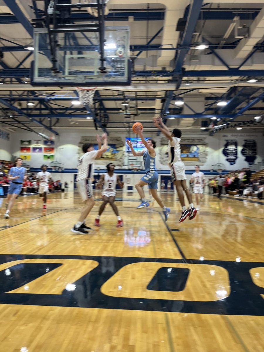 Senior Daniel Laurich goes up for a layup while being guarded by multiple West Aurora players. 