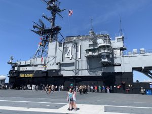 Grace Lube poses in front of the U.S.S. Midway with her siblings, at a young age, ensuring she learned the true history of our country.