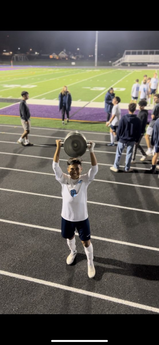 Damian Lagunas holds the Downers Grove crosstown trophy.