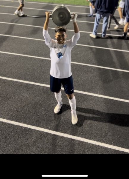 Damian Lagunas holds the Downers Grove crosstown trophy.