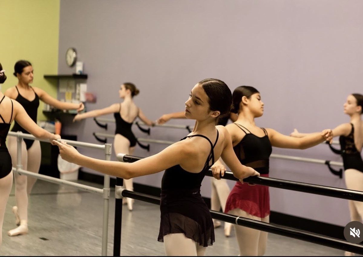 Impact Dance Studio dancers warm up and practice their technique at the ballet barre.