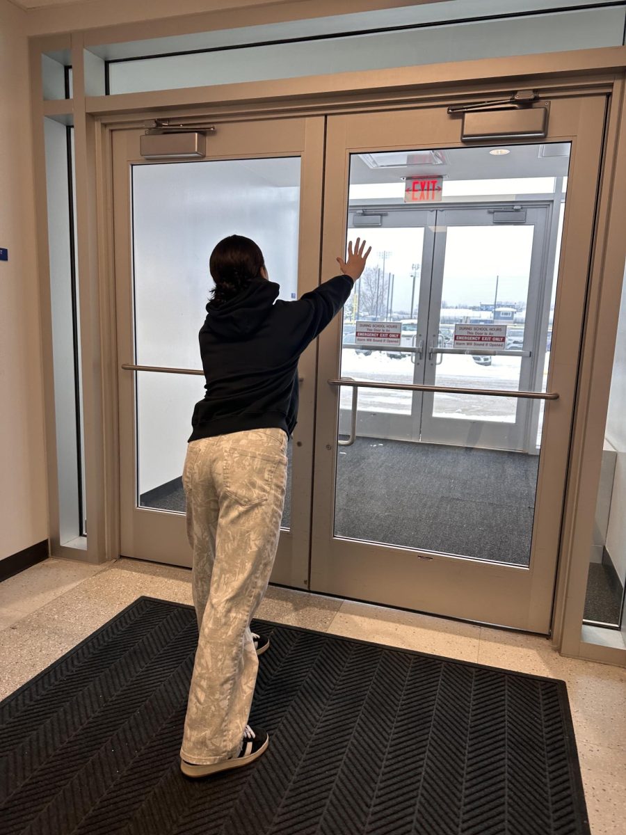 Student reaching out the doors of school ready for the semester to be over.