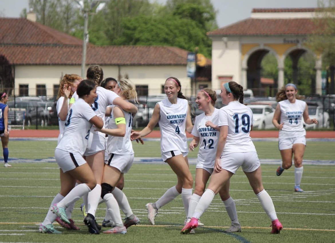 The team uplifts each other after a hard-earned goal. 