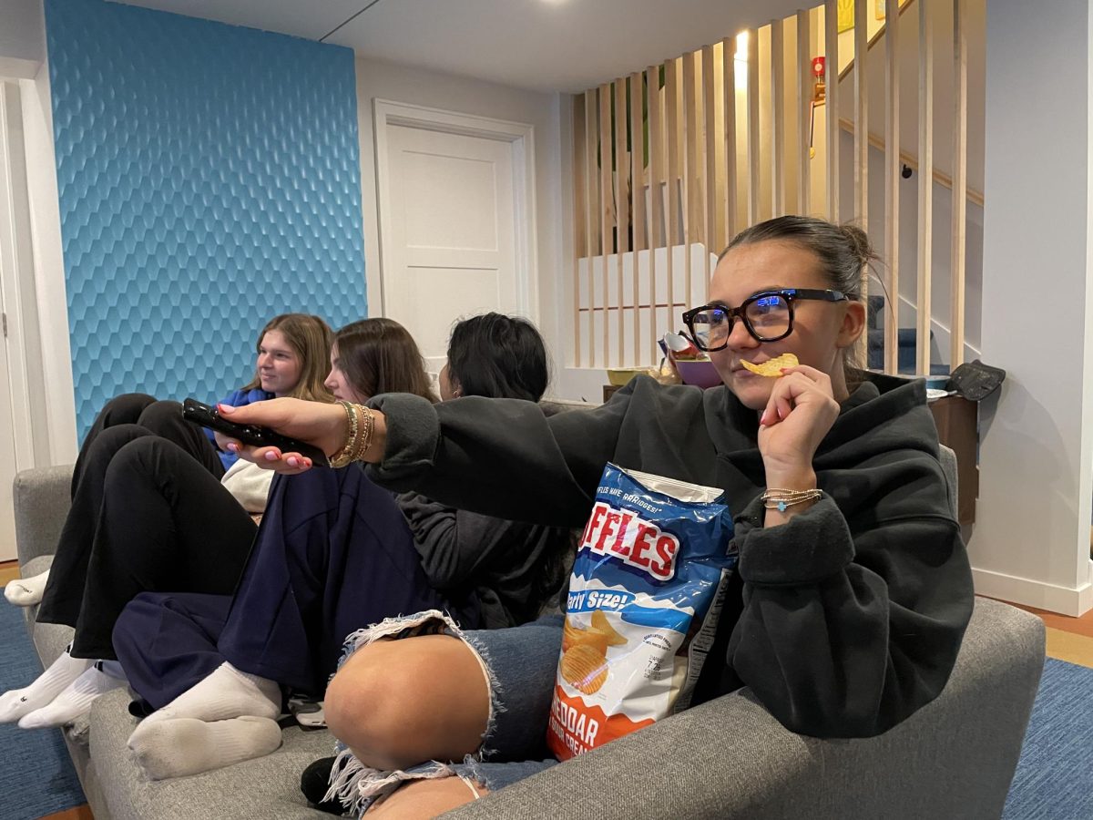 With her friends, junior Maddie Daehnke browses the wide selection of romantic-comedy movies available on TV. 
