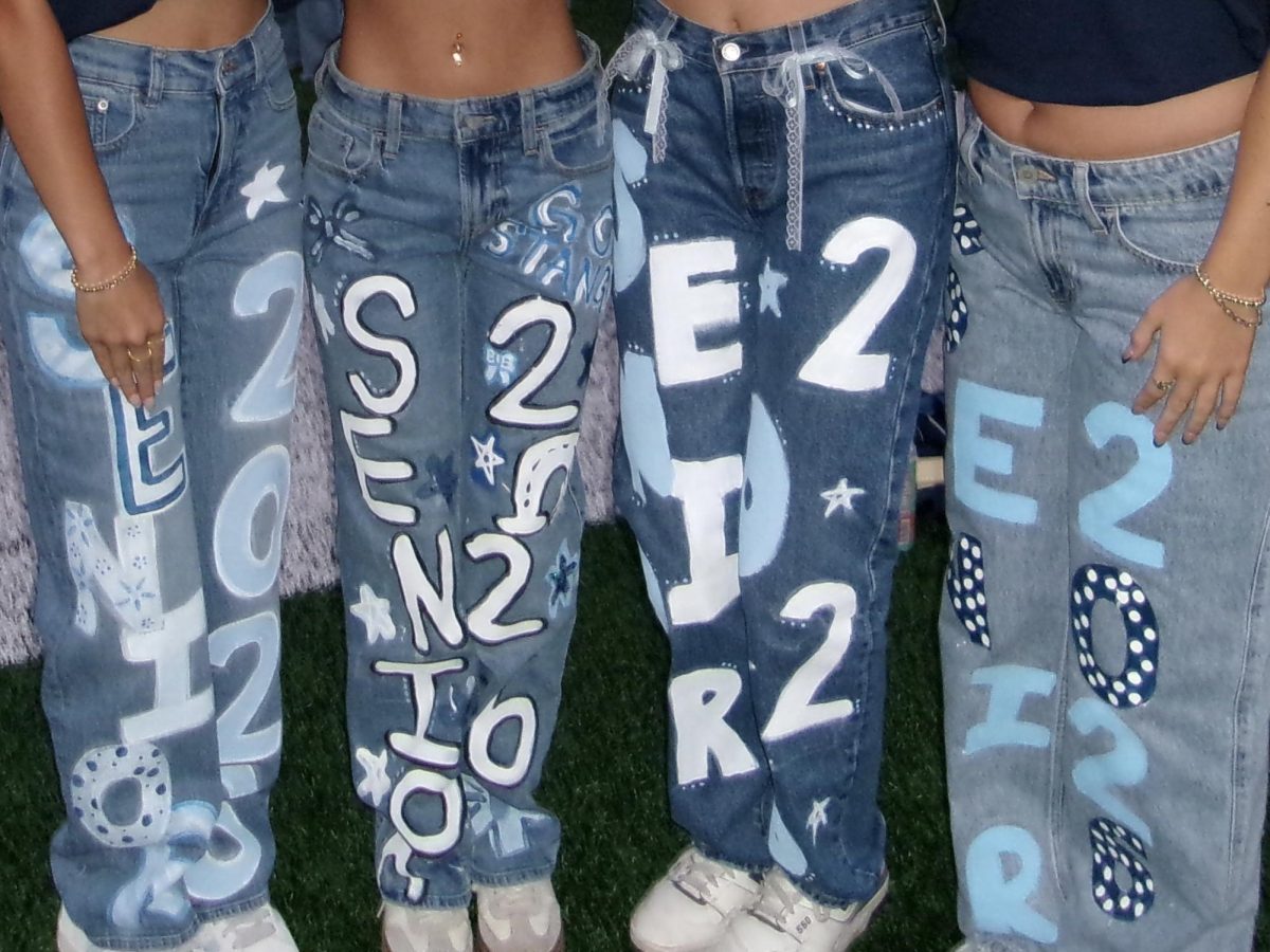 The class of 2026 shows off the jeans they painted to commemorate their final year. // La promoción de 2026 muestra los pantalones vaqueros que ellos pintaron para conmemorar su último año.
