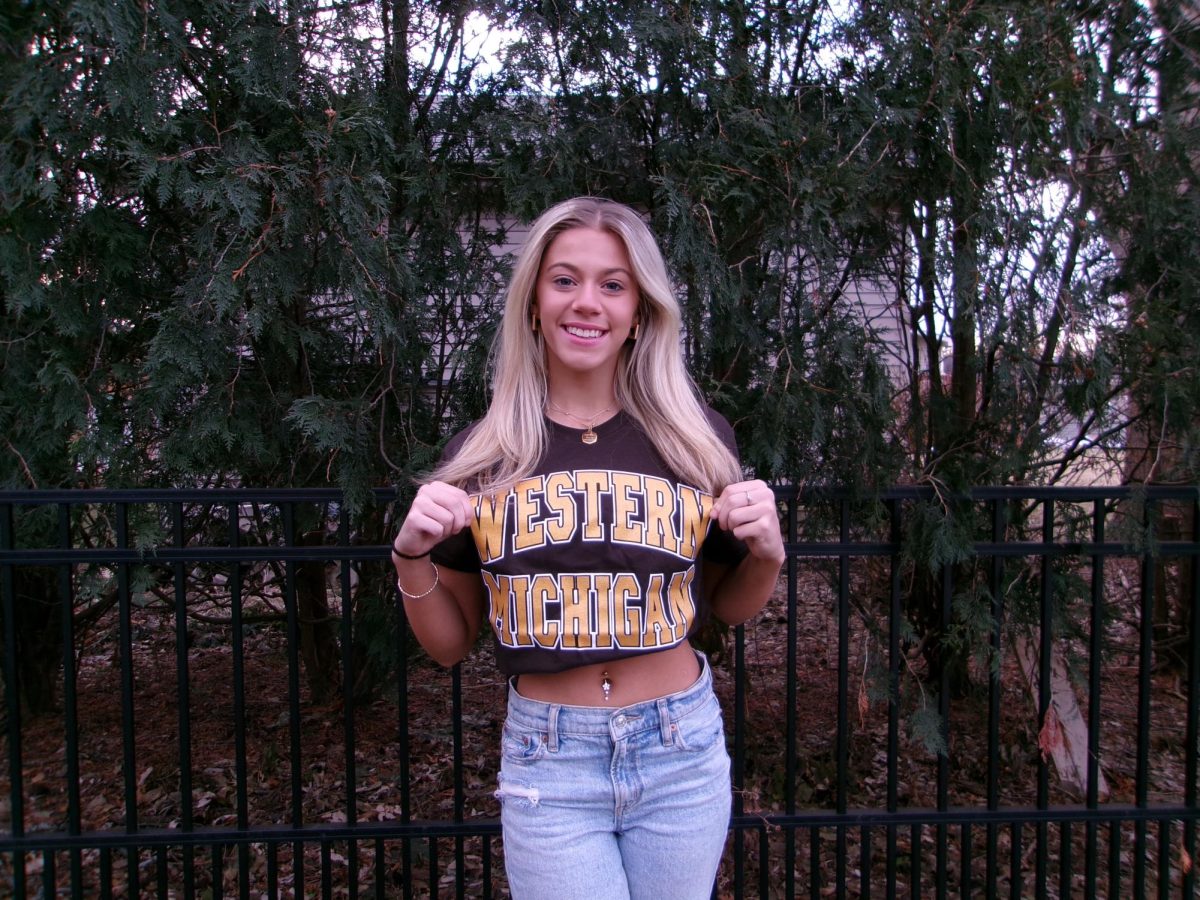 Senior Aubrey Dron shows off her Western Michigan University T-shirt, the college she is committed to for cheerleading. // Aubrey Dron muestra su camiseta de La Universidad de Western Michigan, la universidad que va a ir para la animación.
