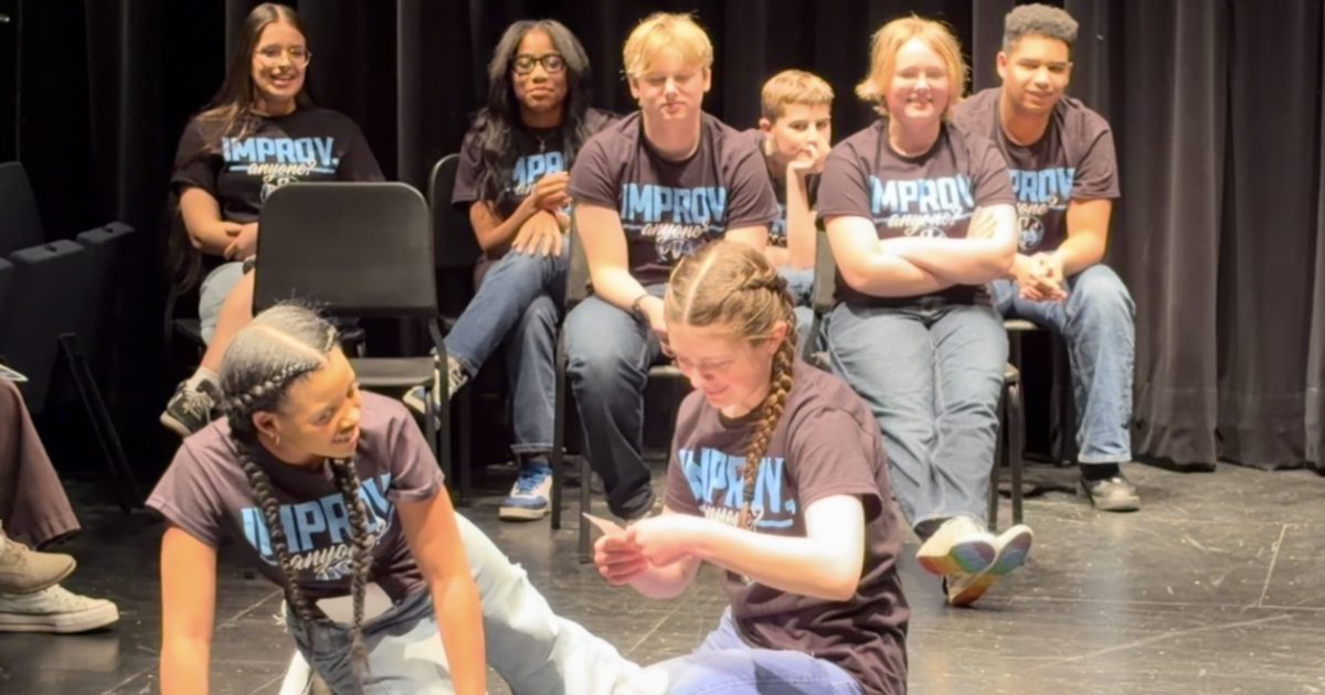 Performances participate in a partner improv game. 